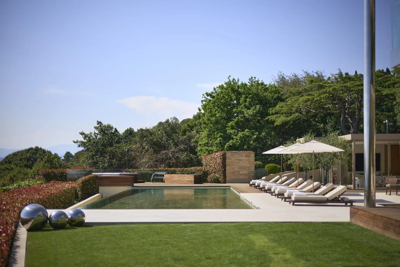 Piscine à débordement, sculptures et pelouse jardin