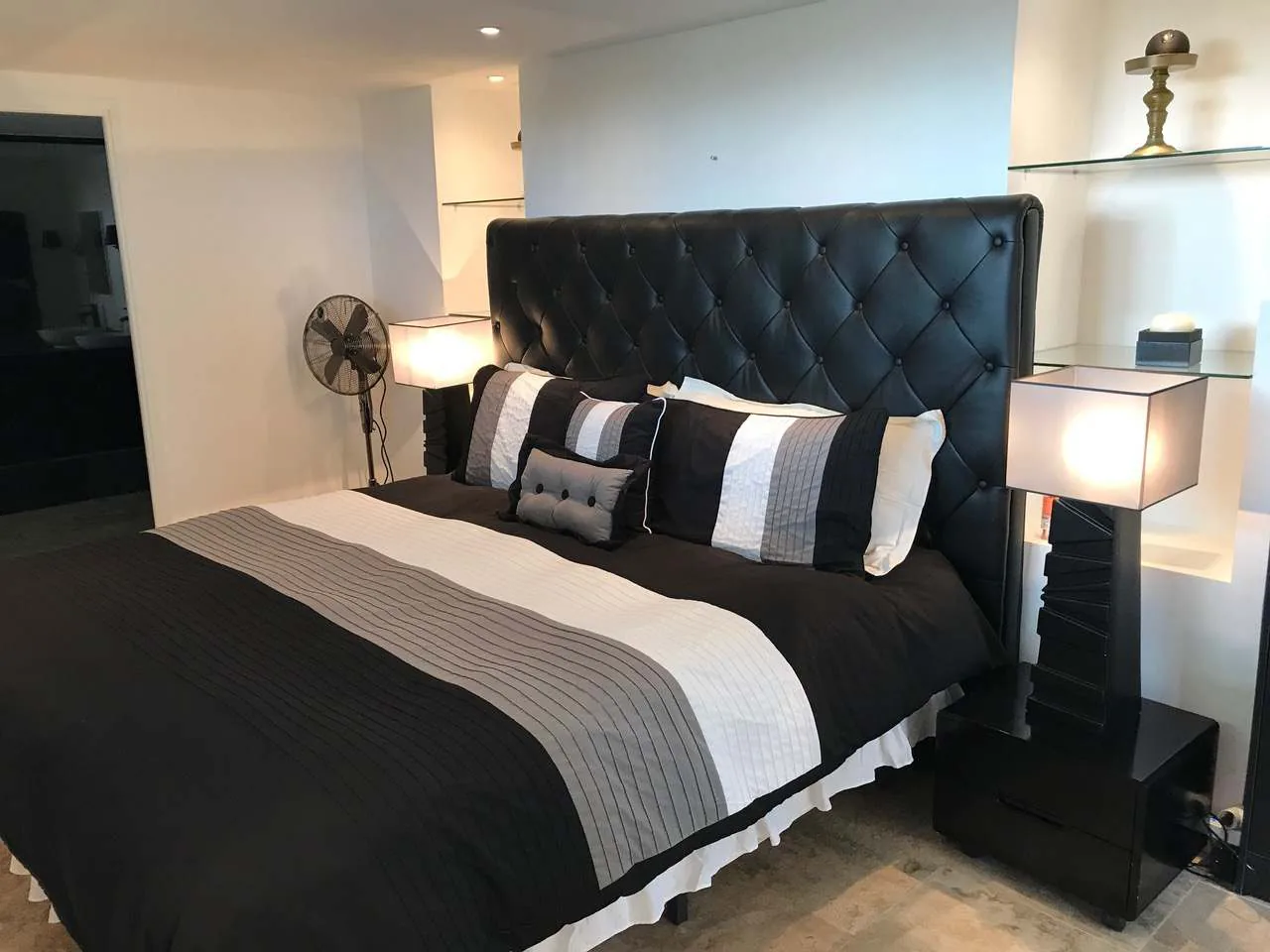 Chambre au niveau jardin avec tete de lit en cuir capitonne noir et linge de lit graphique