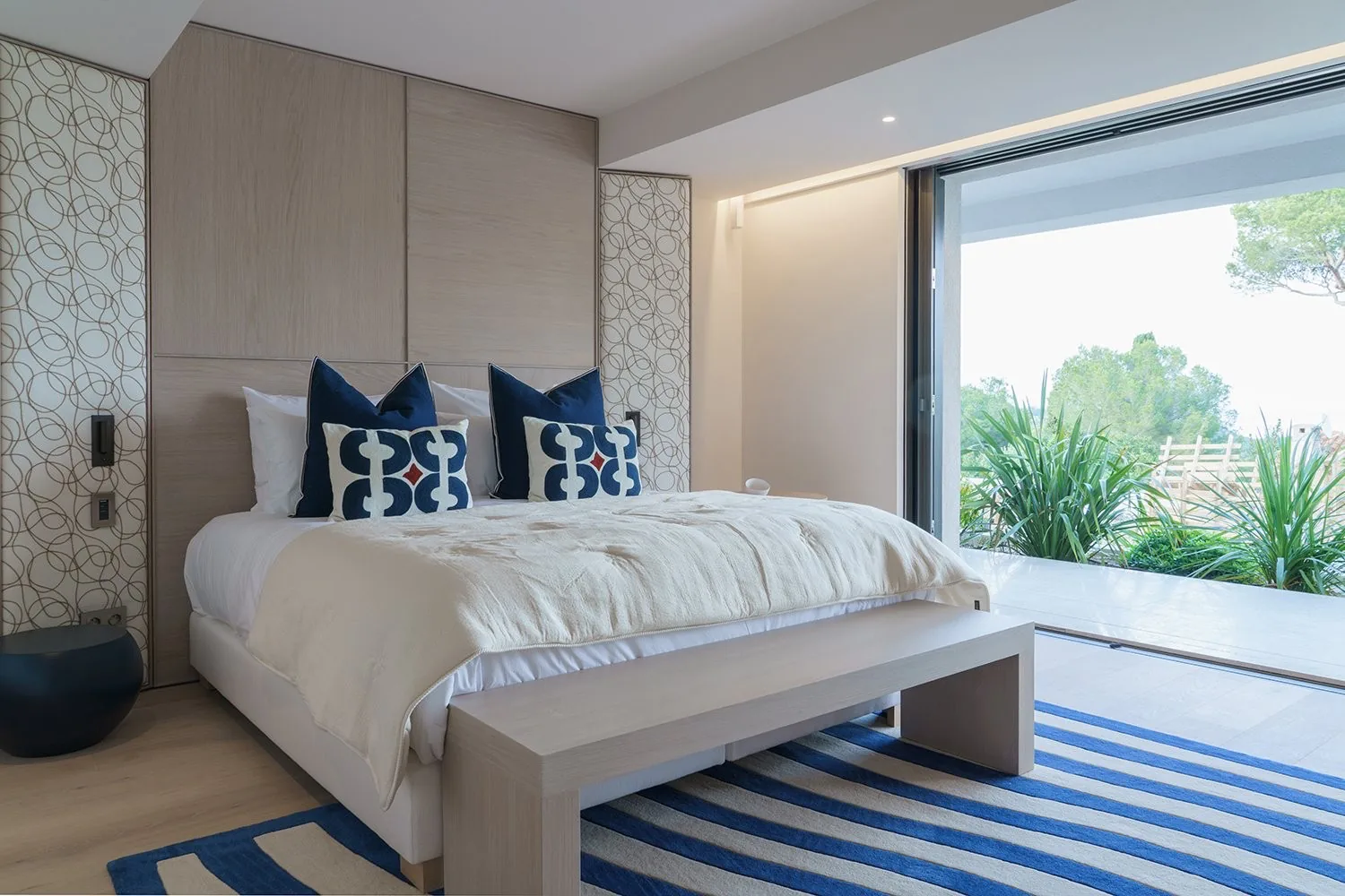 Chambre king coussins bleus et tapis raye marine