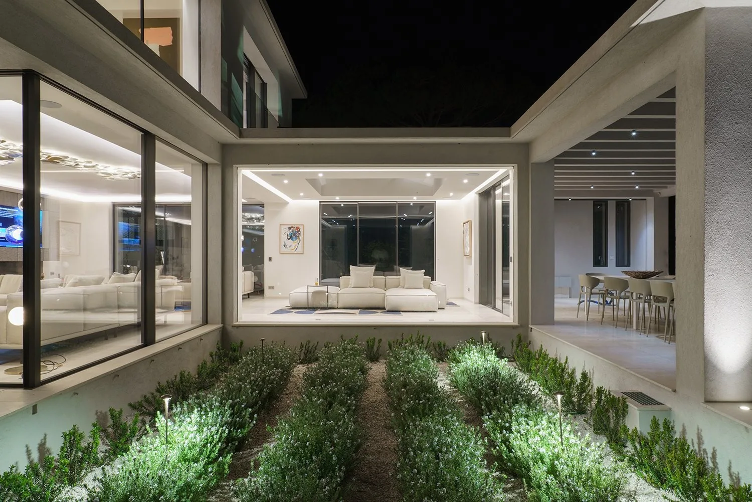 Patio interieur paysager illumine, vue sur les salons