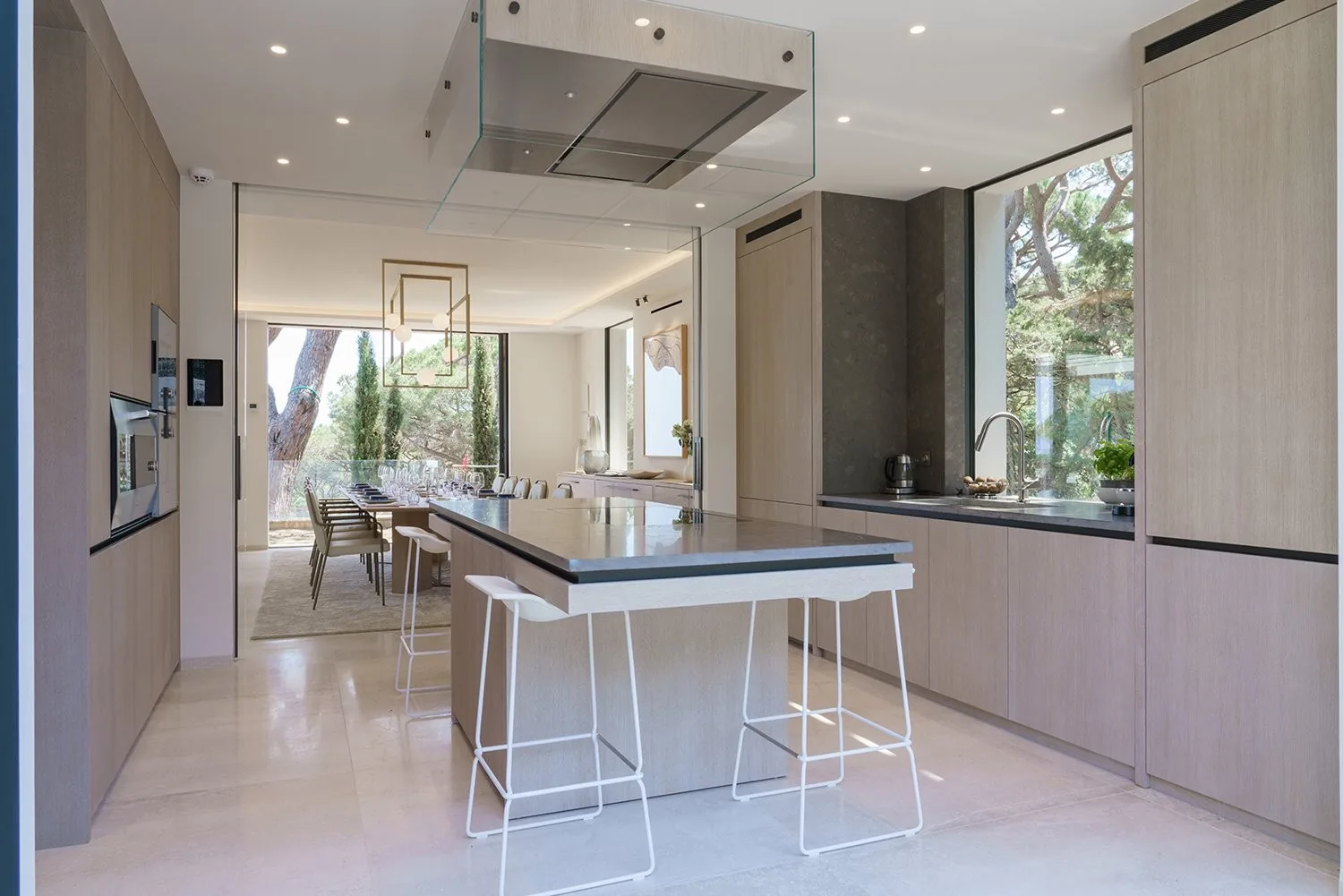 Cuisine designer ilot central avec salle a manger en arriere-plan