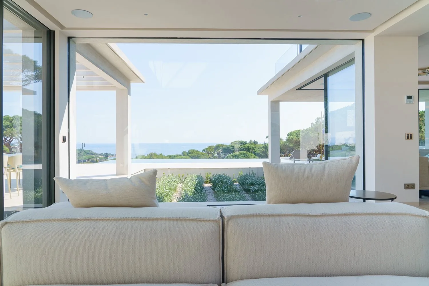 Salon canape ecru face au patio paysager interieur