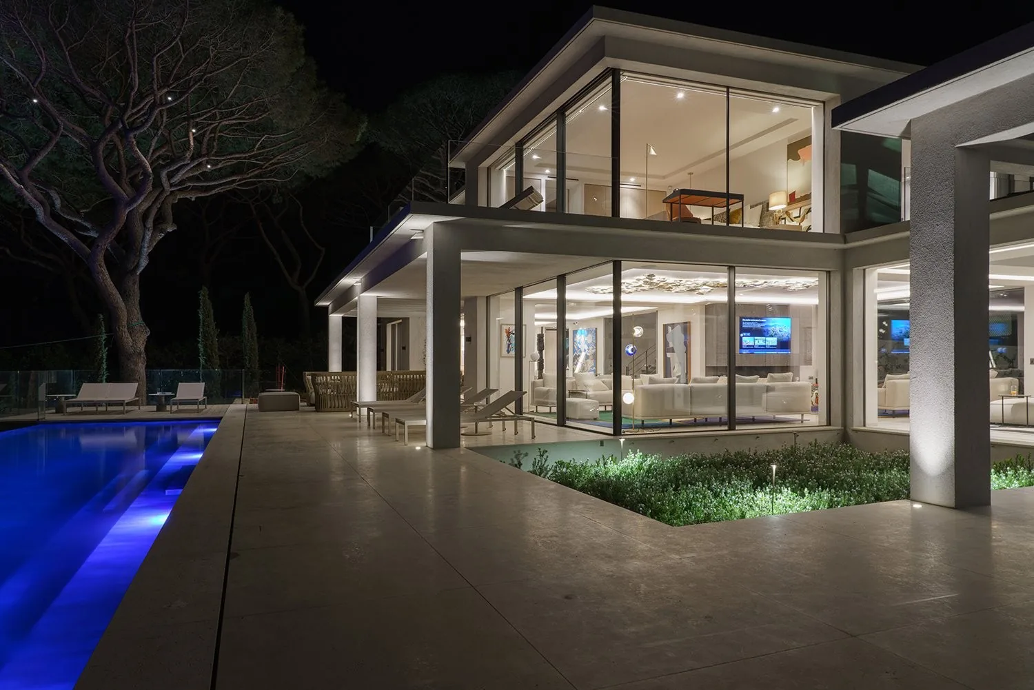 Facade illuminee de nuit, piscine bleue electrique