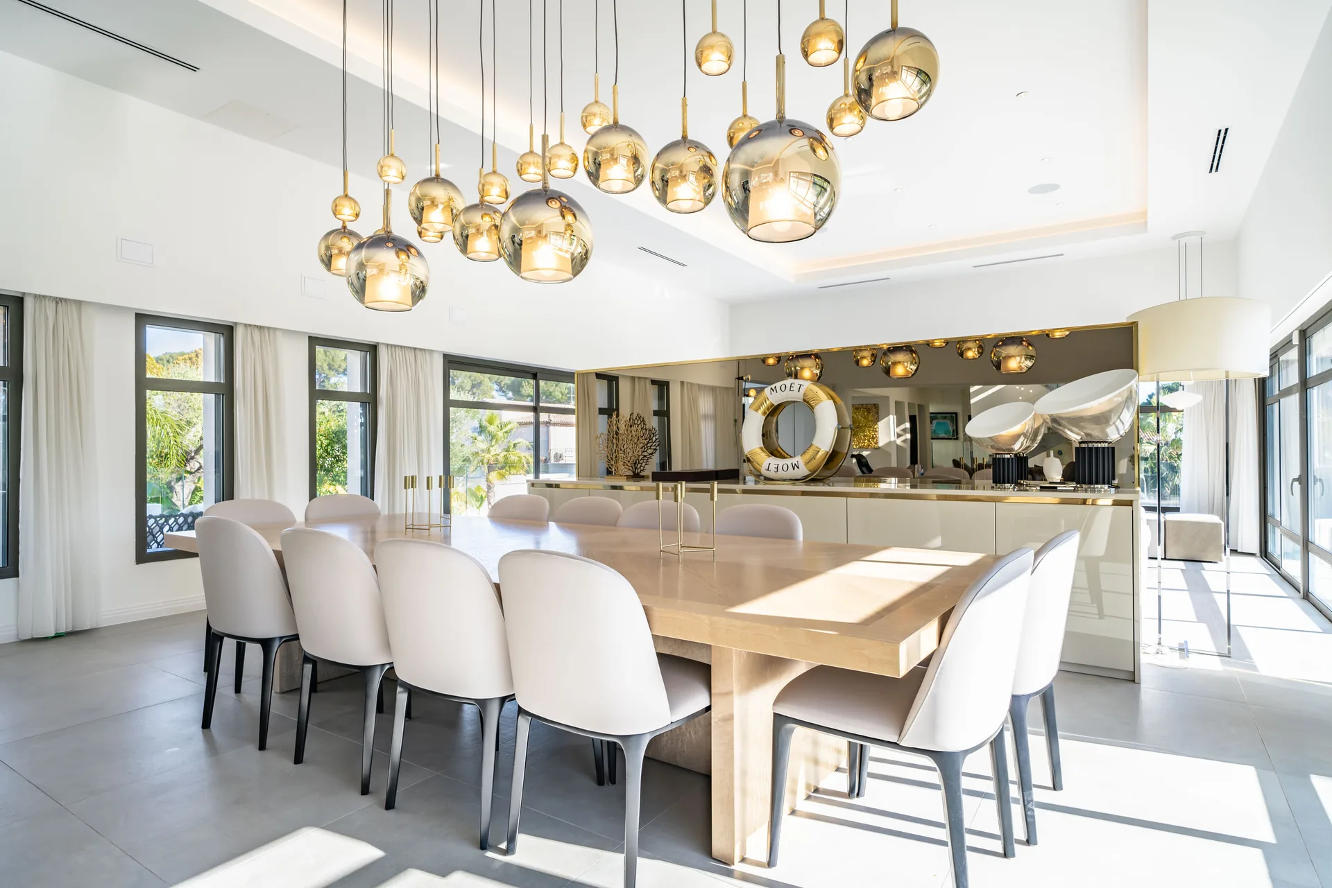 Salle à manger bois clair avec 12 chaises blanches et suspensions globe
