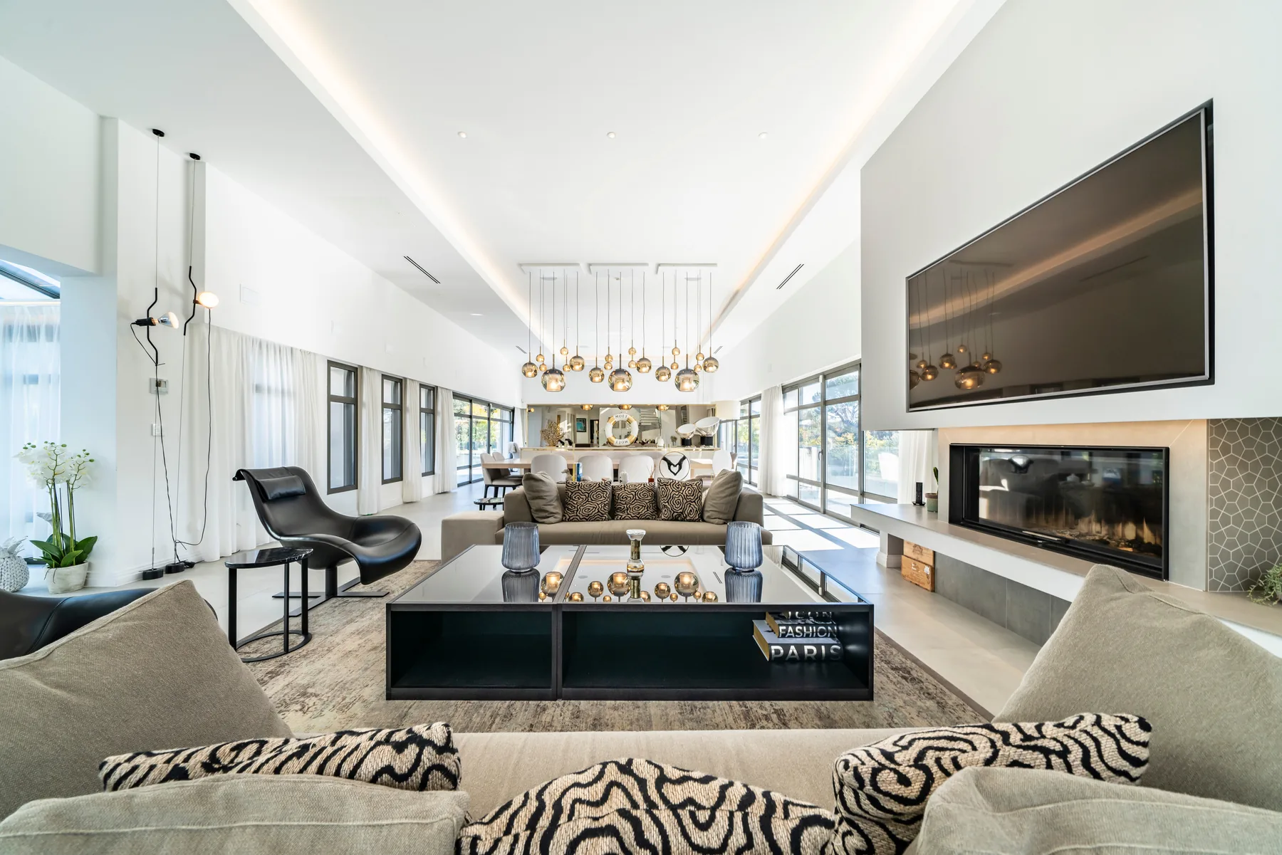 Grand salon contemporain avec canapés velours gris et mur panneaux capitonnés