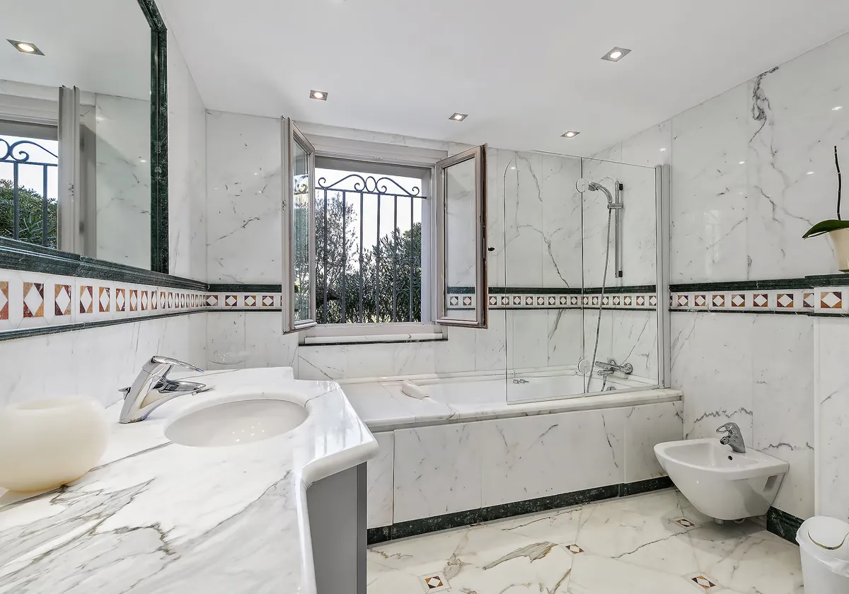 Salle de bain marbre avec frise mosaïque et baignoire