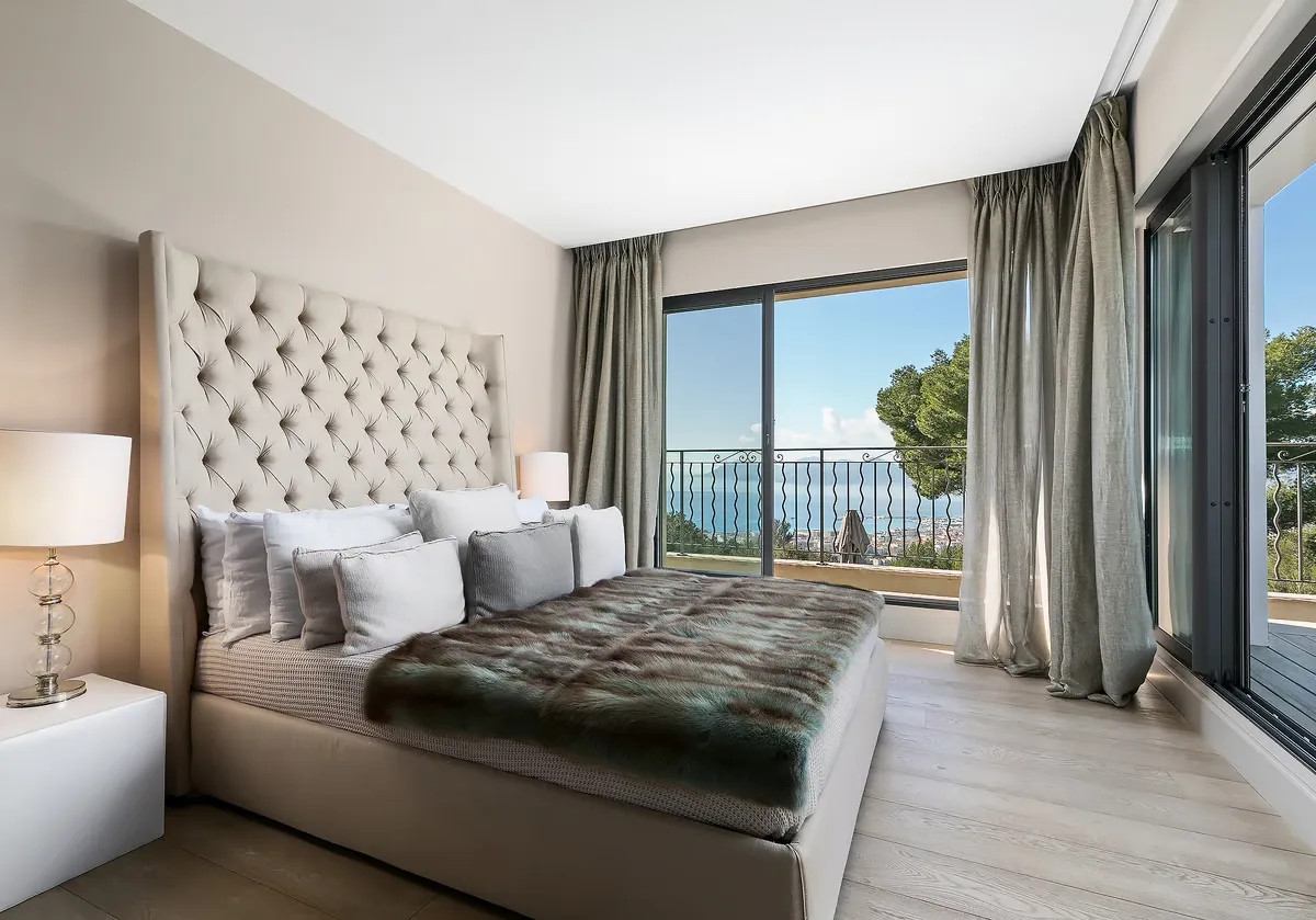 Chambre invités avec tête de lit capitonnée et vue mer