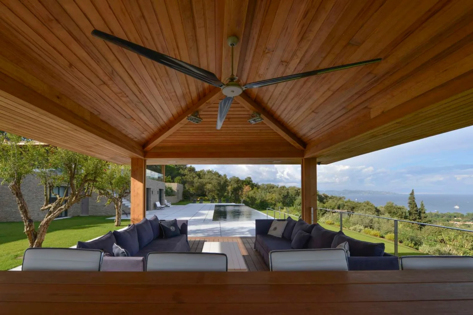 Terrasse couverte bois avec ventilateur, vue piscine