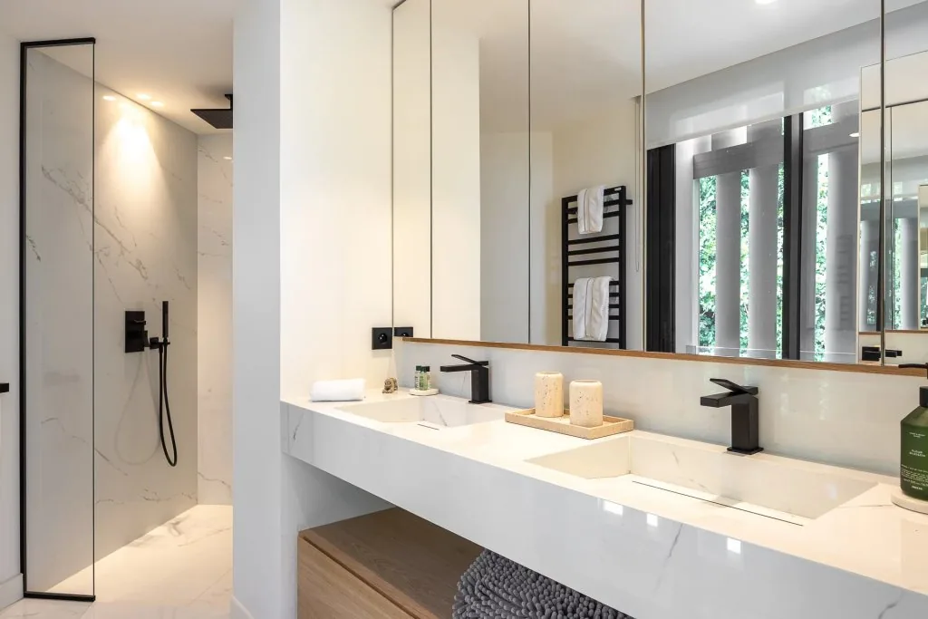 Salle de bain marbre avec robinetterie noire et sèche-serviettes design