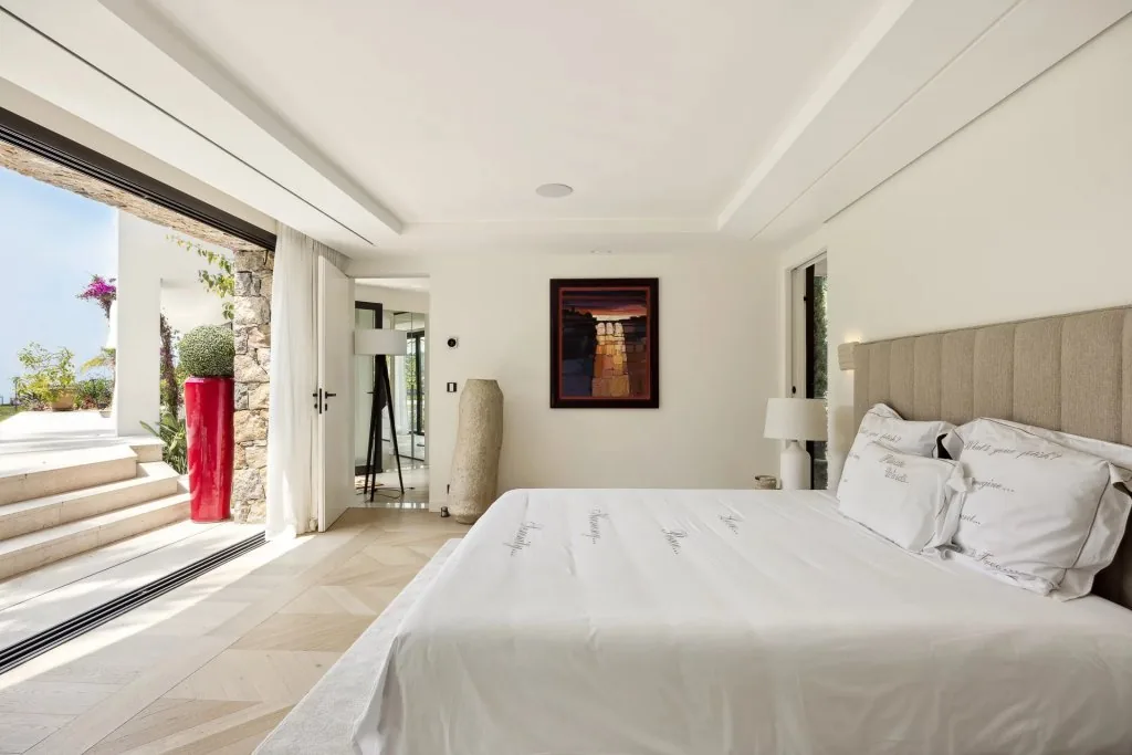 Chambre invités avec entrée en pierre claire, vue jardin et oeuvre encadrée