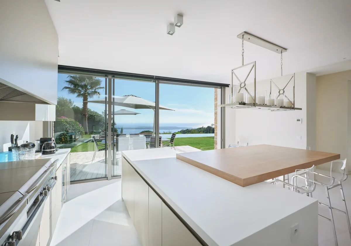 Cuisine vue mer avec suspensions design et îlot massif