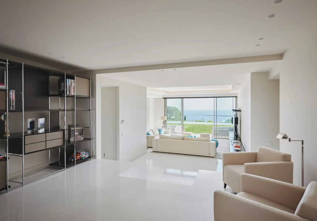 Salon avec bibliothèque en perspective et baie vitrée sur baie de Cannes