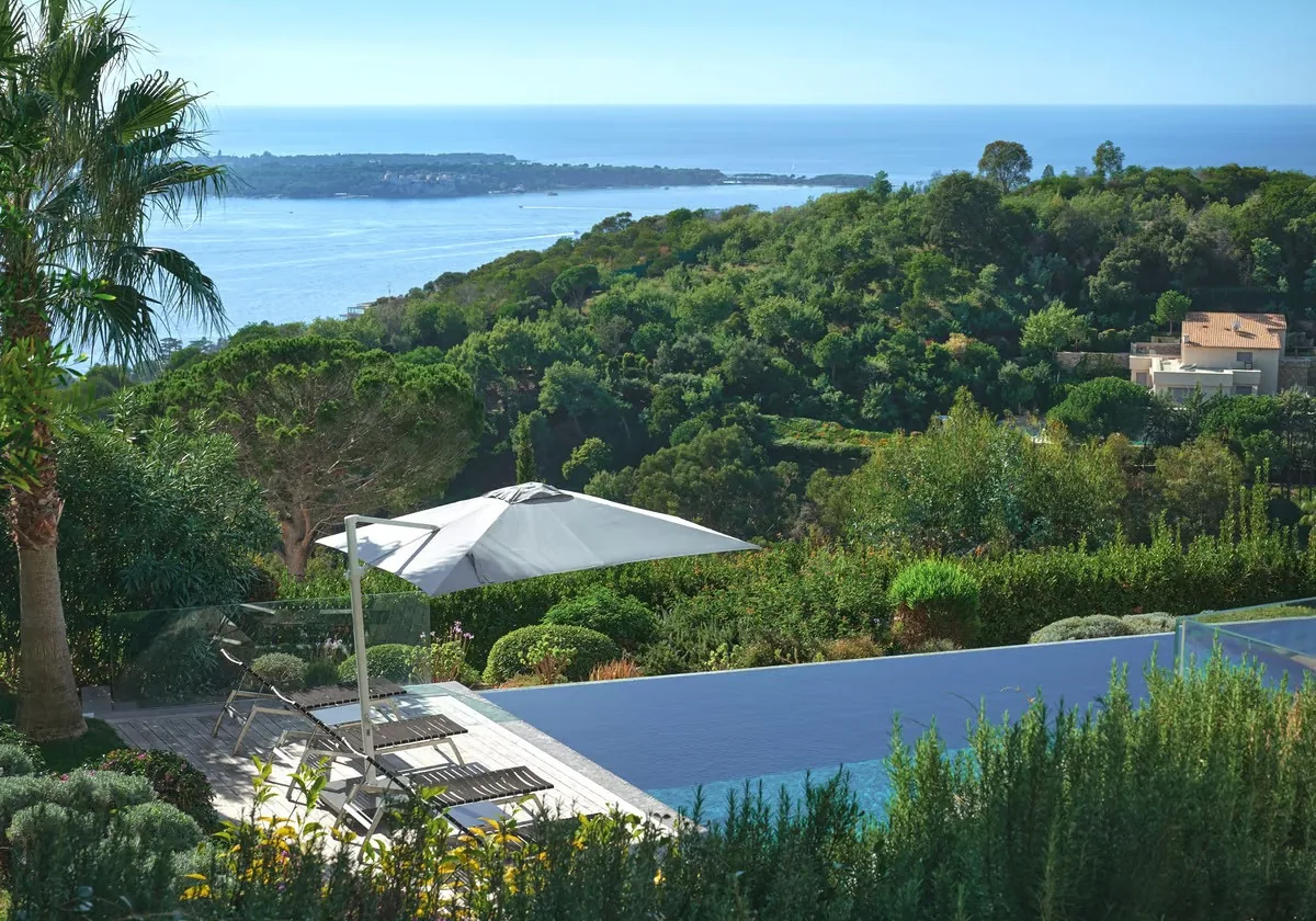 Bains de soleil et parasol côté piscine vue îles de Lérins