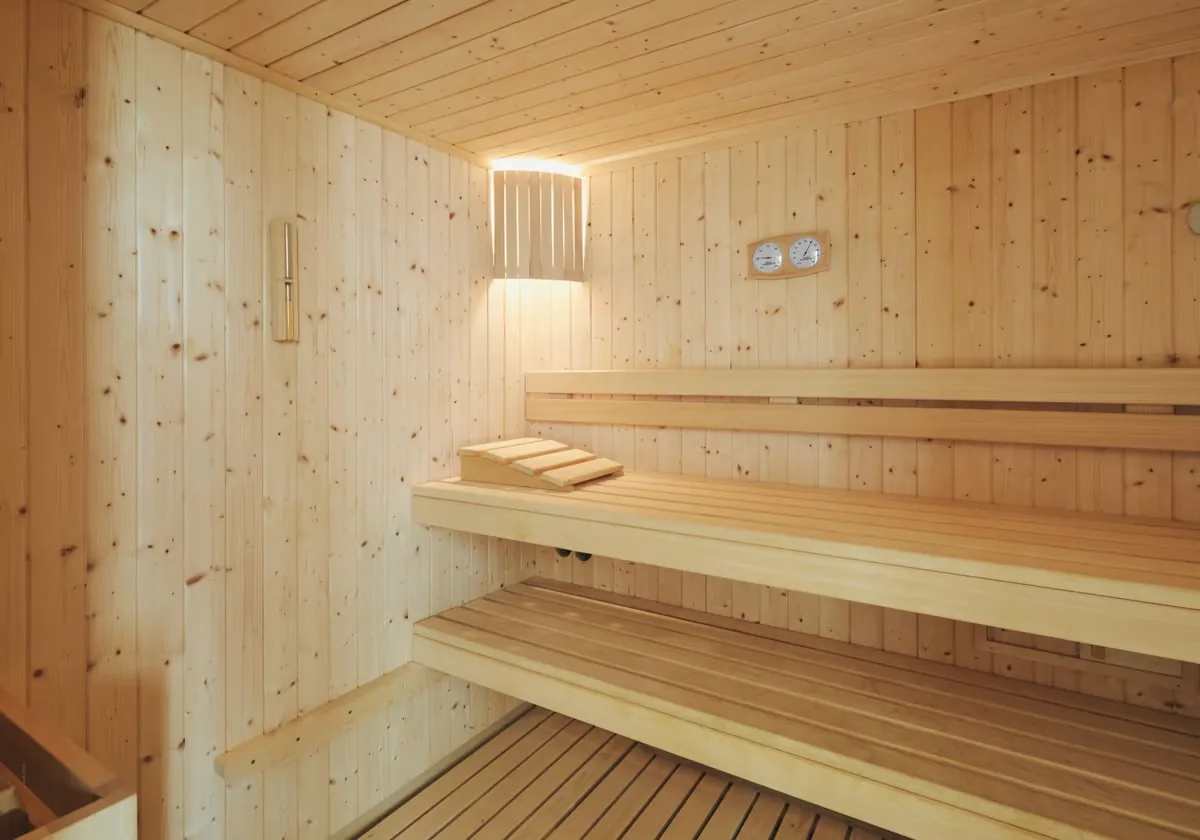 Sauna scandinave en bois clair avec banquettes deux niveaux