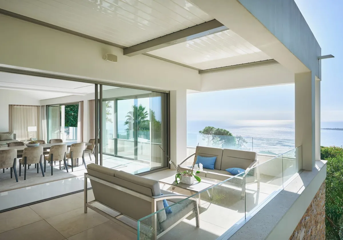 Terrasse couverte avec salon extérieur et vue baie