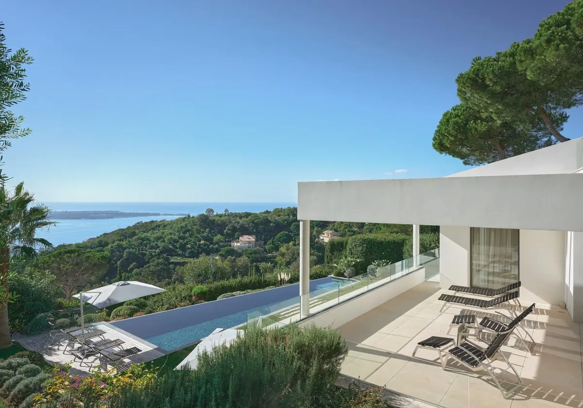 Terrasse couverte avec bains de soleil et piscine vue mer