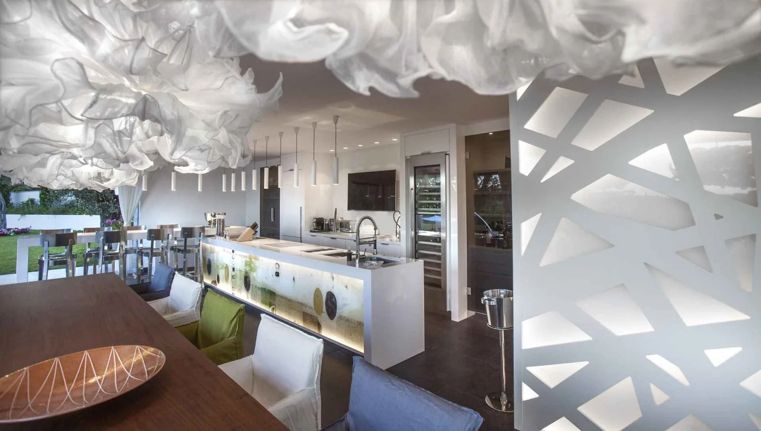 Cuisine ouverte avec luminaire sculptural et îlot blanc