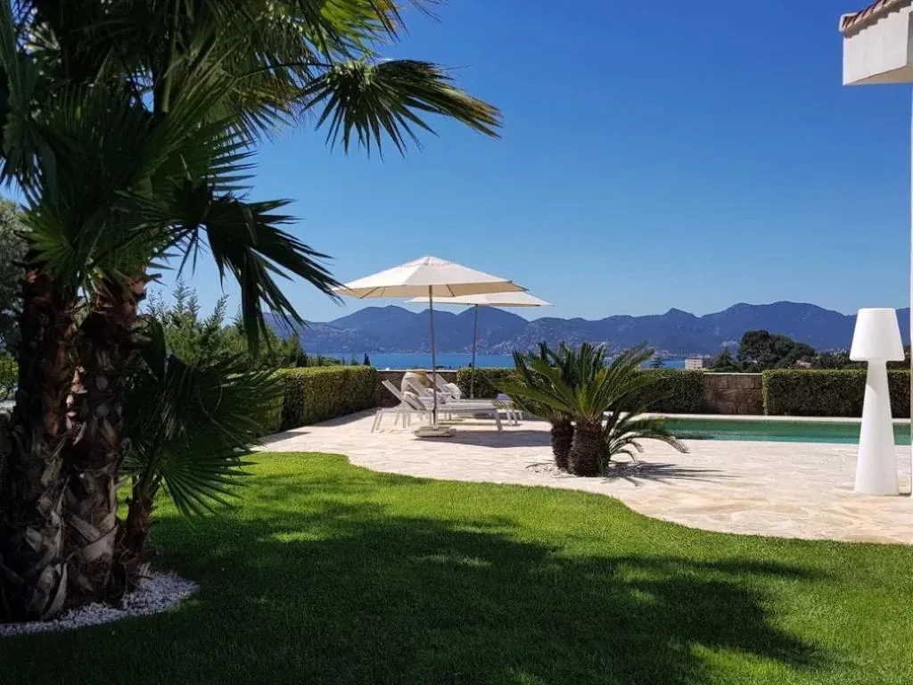 Jardin avec palmier piscine et vue panoramique mer et montagnes