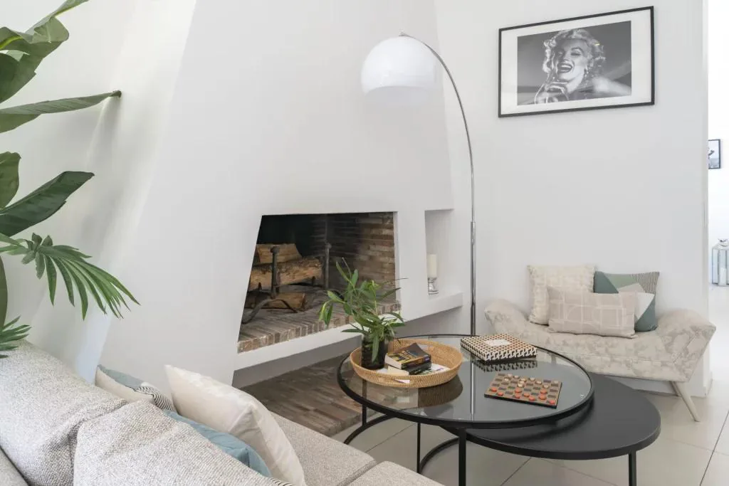 Coin salon cheminée avec banquette bois et lampe arc